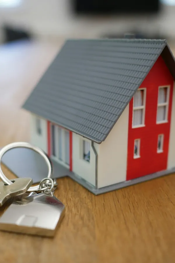 A model house and a set of keys on a wooden table
