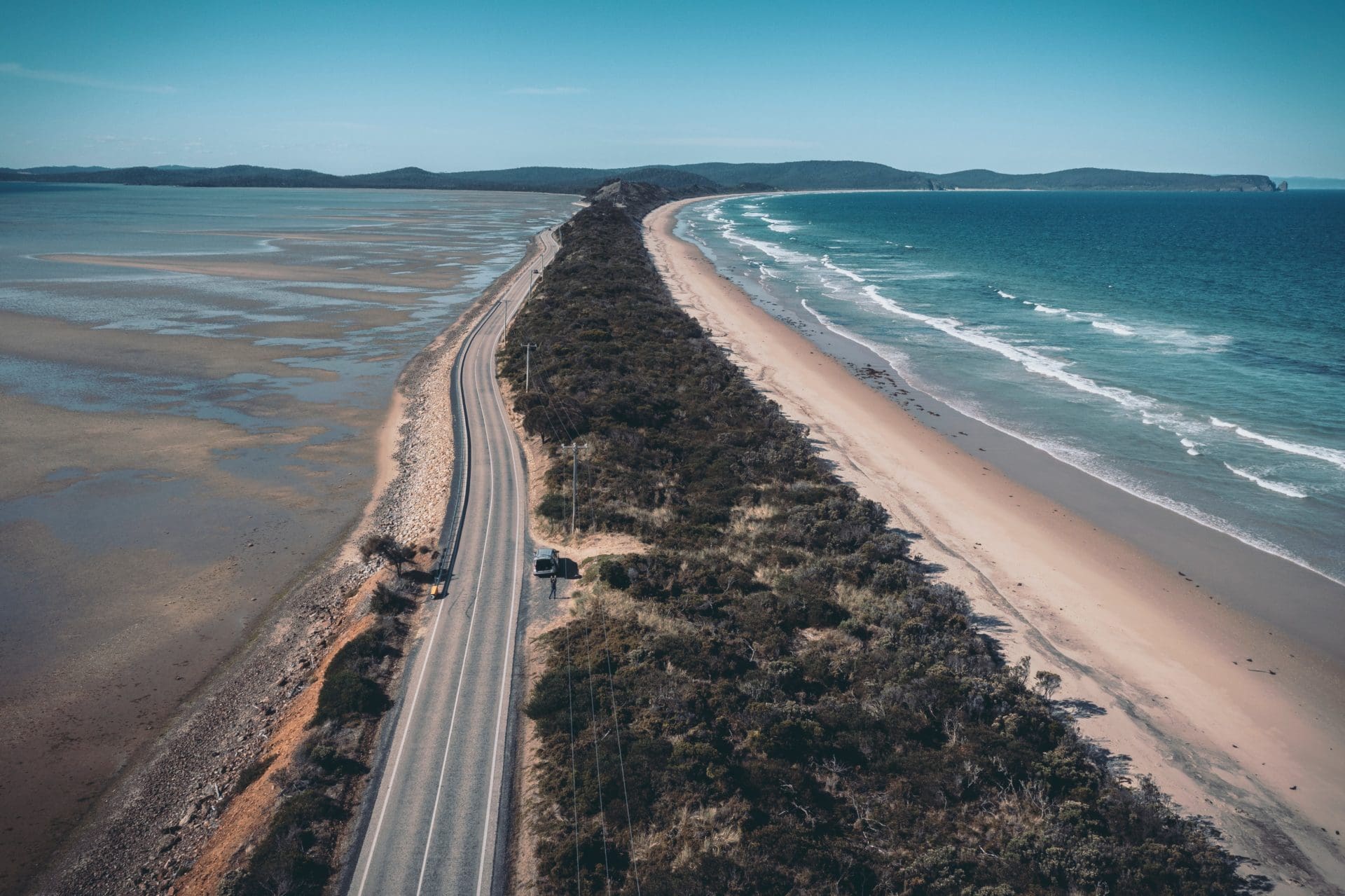 Aerial view of a road leading to the ocean in Tasmania where the Tasmanian Web Company is located.